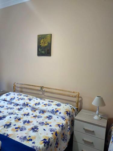 a bedroom with a bed and a nightstand and a picture on the wall at B&B Sulla Spiaggia in Belmonte Calabro