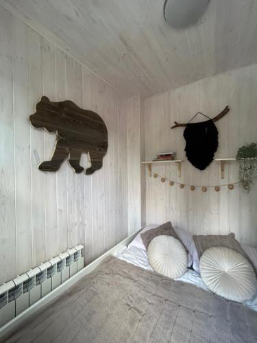 a room with a bed in a wooden wall at Apartamenty Jagodzianka - Jacuzzi, Sauna, Tężnia solankowa in Ustrzyki Dolne