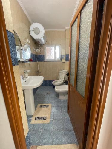 une salle de bain avec toilettes et lavabo dans l'établissement Tea's Apartament, à Berat
