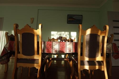 a dining room table with two chairs and a table with a tablecloth at David B&B in Sisian