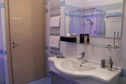 ein Bad mit einem Waschbecken, einem Spiegel und einer Dusche in der Unterkunft Ely'S Residence in Romano D'Ezzelino