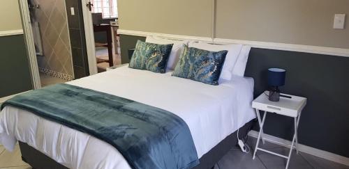 a bedroom with a large white bed with blue pillows at Happy Haven in Welkom