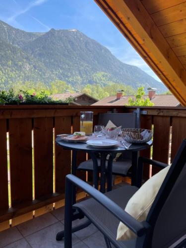 a table on a balcony with a view of a mountain at Das Bergquartier - Ferienwohnung Krottenkopf in Oberau