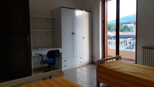 a bedroom with a bed and a cabinet and a window at La casa sul mare in Patti