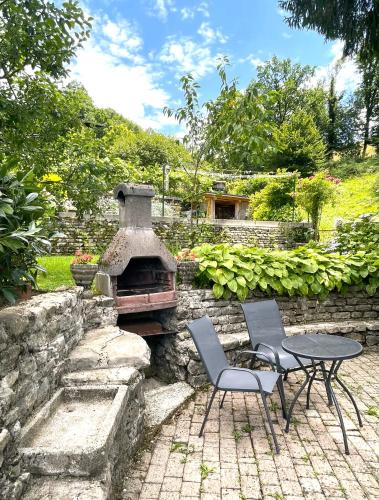 a patio with a table and two chairs and a stone oven at Apartma Savan in Tolmin