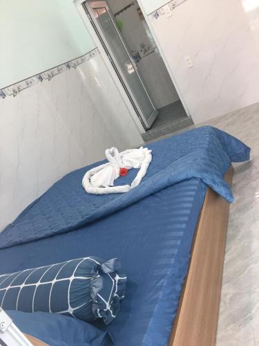 a bed in a room with a blue bedsheet at SEA HOME HOMESTAY in Ấp Bình Hưng