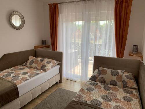 salon z kanapą i oknem w obiekcie Dodi Apartman w Zalakaros