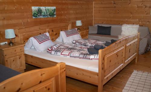 a bedroom with two beds in a wooden cabin at RANGERSDORFER HÜTTE in Witschdorf
