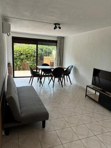 a living room with a couch and a table and chairs at Appartement proche de la mer in Sainte-Marie-la-Mer