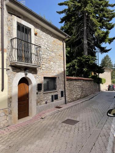 a stone building with a door and a balcony at 18th Century Samnium Stone Residence in Alfedena