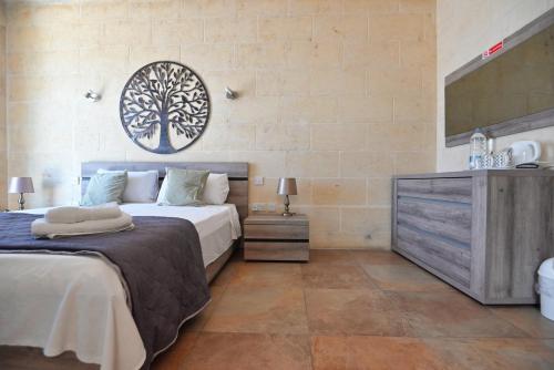 a bedroom with two beds and a television in it at The Cloisters Bed And Breakfast in Xagħra
