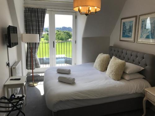 a bedroom with a large bed with a large window at Stylish Victorian Apartment's close to the Botanical gardens, Free parking! in Edinburgh