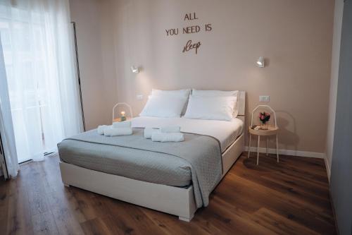 a bedroom with a bed with a sign that reads all you need is here at Next stop Ostia in Lido di Ostia