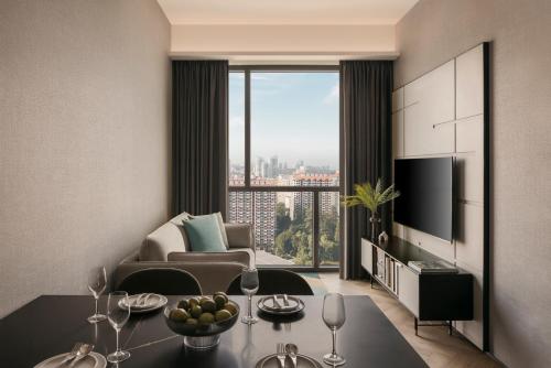 a living room with a table and a large window at Quincy House Singapore in Singapore
