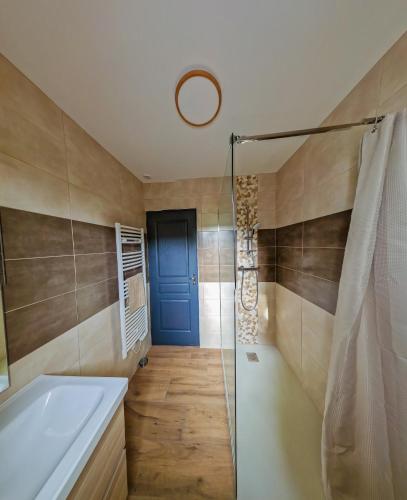 La salle de bains est pourvue d'une douche, d'une baignoire et d'une porte en verre. dans l'établissement Gîte de Catherine, à Saint-Christophe-des-Bardes