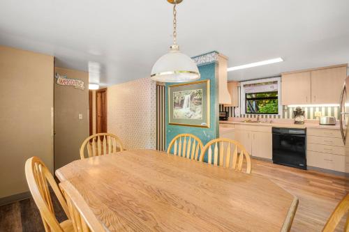 a kitchen and dining room with a wooden table and chairs at Carr's Northside Hotel and Cottages in Gatlinburg