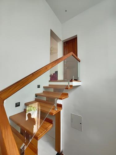 a staircase in a house with a wooden railing at Tranquil Home in Trivandrum