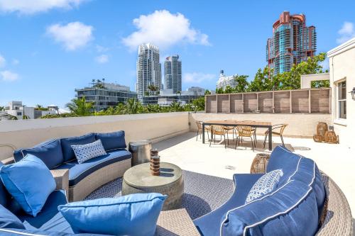 a patio with blue furniture and a table on a roof at Gorgeous coastal PH with Large Private Terrace in Miami Beach