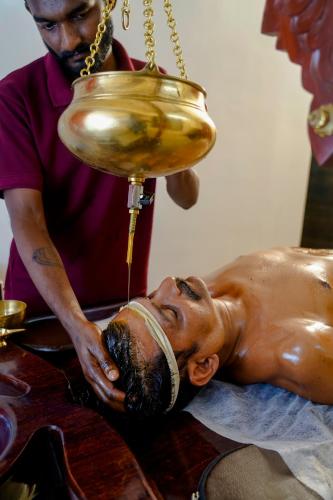 a man giving a statue of a man getting a massage at Vallyath Ayurveda By BRDGE HOSPITALITY in Ernakulam