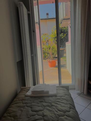 a bedroom with a bed and a large window at Civico 21-FreeParking in Vescovato