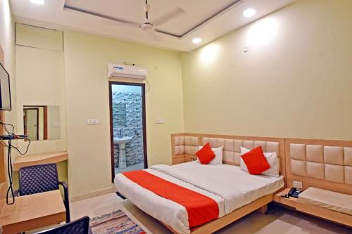a bedroom with a bed with red pillows at Hotel Maharaja Palace in Alīgarh