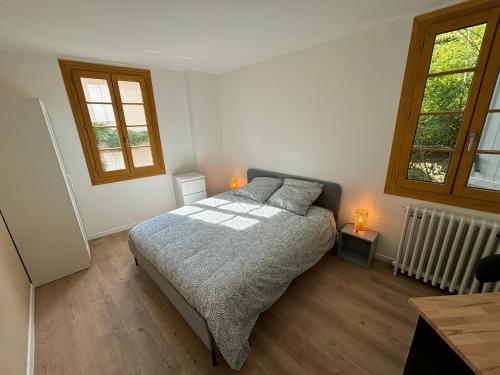 - une chambre avec un lit avec deux oreillers et deux fenêtres dans l'établissement L'Architecte, à Figeac