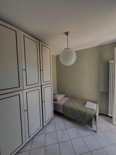 a bedroom with a bed and a large white cabinet at Civico 21-FreeParking in Vescovato