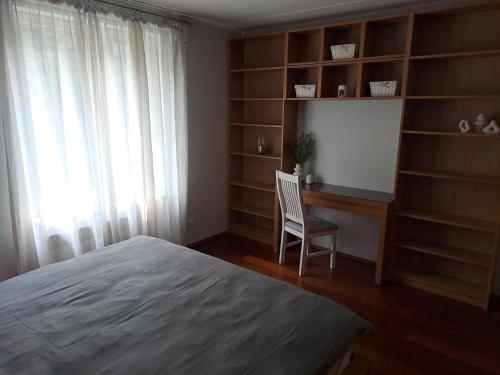 a bedroom with a bed and a desk and a chair at Tolli 12 Apartment in Kuressaare