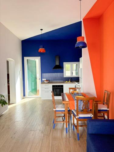 a kitchen and dining room with an orange and blue wall at Casa Giù in Cecina