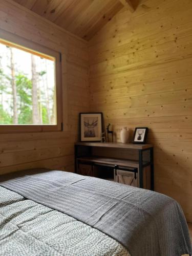 a bedroom with a bed and a window in a log cabin at Stary Las Siemczyno in Siemczyno