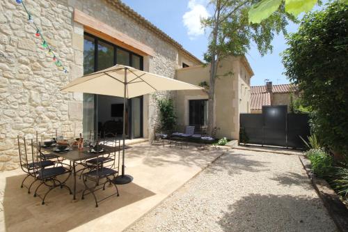 a patio with a table and an umbrella at Villa Betty -piscine chauffée- in Paradou