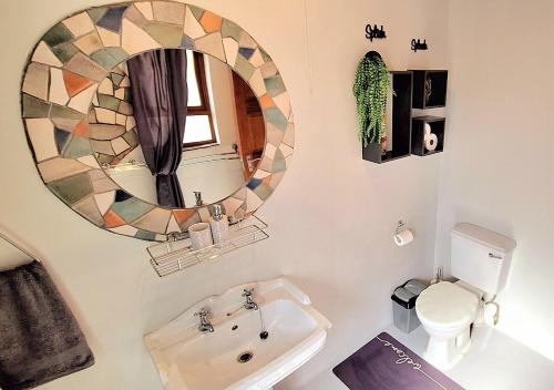a bathroom with a mirror and a toilet and a sink at Stay at Fairway in Centurion