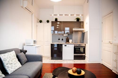 un salon avec un canapé et une cuisine dans l'établissement La Bastide, à Carcassonne