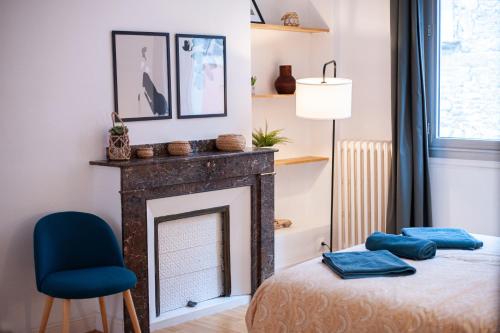 - une chambre avec une cheminée et une chaise bleue dans l'établissement La Bastide, à Carcassonne