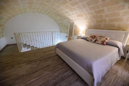 a bedroom with a bed and a brick wall at La Chicca nel Centro in Massafra