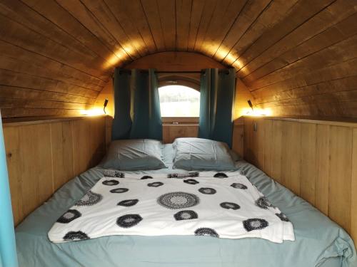 - un lit au milieu d'une petite pièce dans l'établissement Tonneau normand insolite, à Le Mesnil-Germain