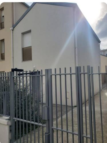 une clôture métallique devant un bâtiment dans l'établissement Maison avec jardin et 2 places de parking, à Orly