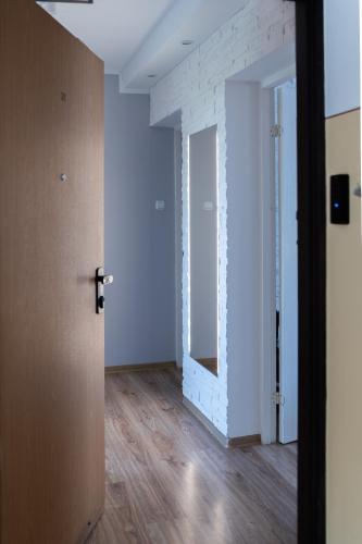 an empty room with white walls and wooden floors at Apartament na Polnej in Chełmno