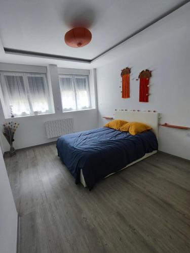 une chambre avec un lit dans une pièce blanche dans l'établissement Les orangers, à Ravilloles