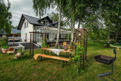 a house with a greenhouse and a bench in the yard at Villa Marta in Trzebinia