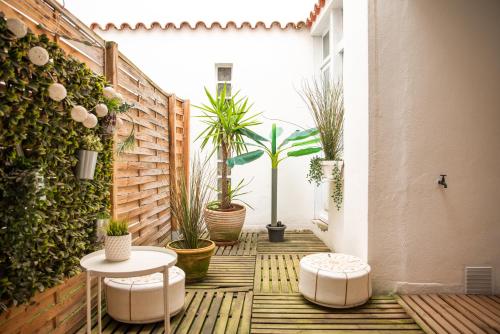 une cour avec des plantes en pot et des tables sur un patio dans l'établissement 101 Cour de la Bastide, à Carcassonne