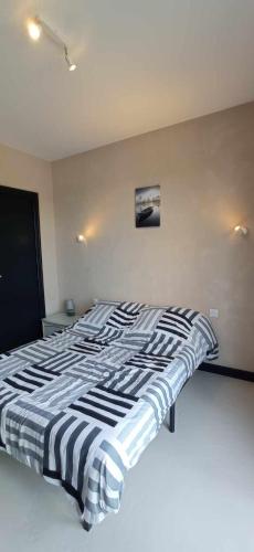 - un lit noir et blanc dans une chambre dans l'établissement Au Domaine de L'étang, à Saint-Priest-sous-Aixe