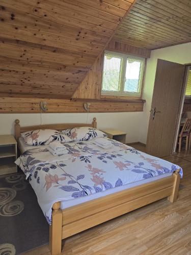 a bedroom with a bed in a room with wooden ceilings at Apartman Majetić in Seliste Dreznicko
