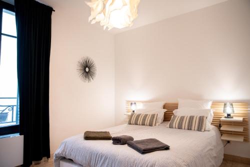 une chambre avec un lit avec deux serviettes dessus dans l'établissement 101 Cour de la Bastide, à Carcassonne