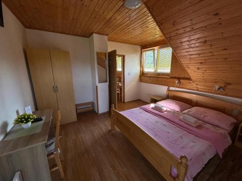 una camera da letto con un letto grande e un soffitto in legno di Apartman Majetić a Seliste Dreznicko