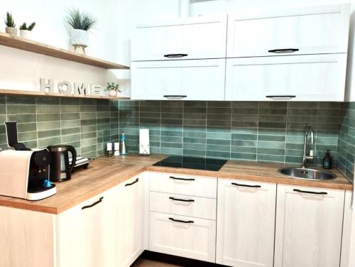 a kitchen with white cabinets and a sink at L'appartamento di Alessandra in Verbania