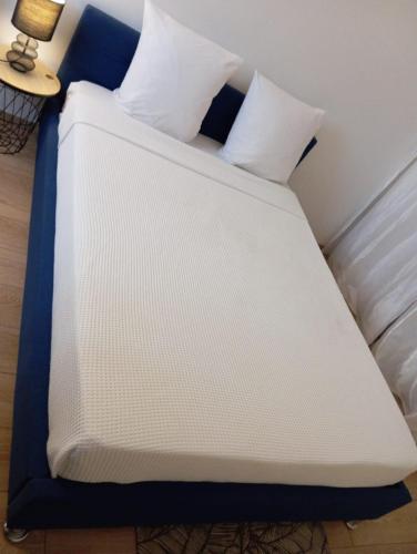 a white and blue bed with two pillows on it at Noxio voyages in Evry-Courcouronnes