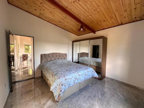 a bedroom with a bed and a large mirror at Casa Pôr do Sol in Baependi
