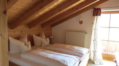 a bedroom with a large white bed in a room at Landhaus Am Arzbach in Bad Tölz