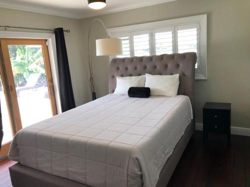 a bedroom with a large bed with a large window at Bright and Cheerful 4 bedroom Home with pool in Boca Raton